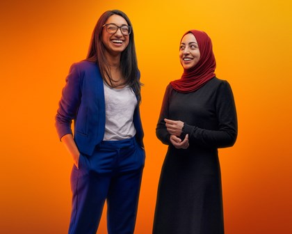 Two Smiling People Orange Background