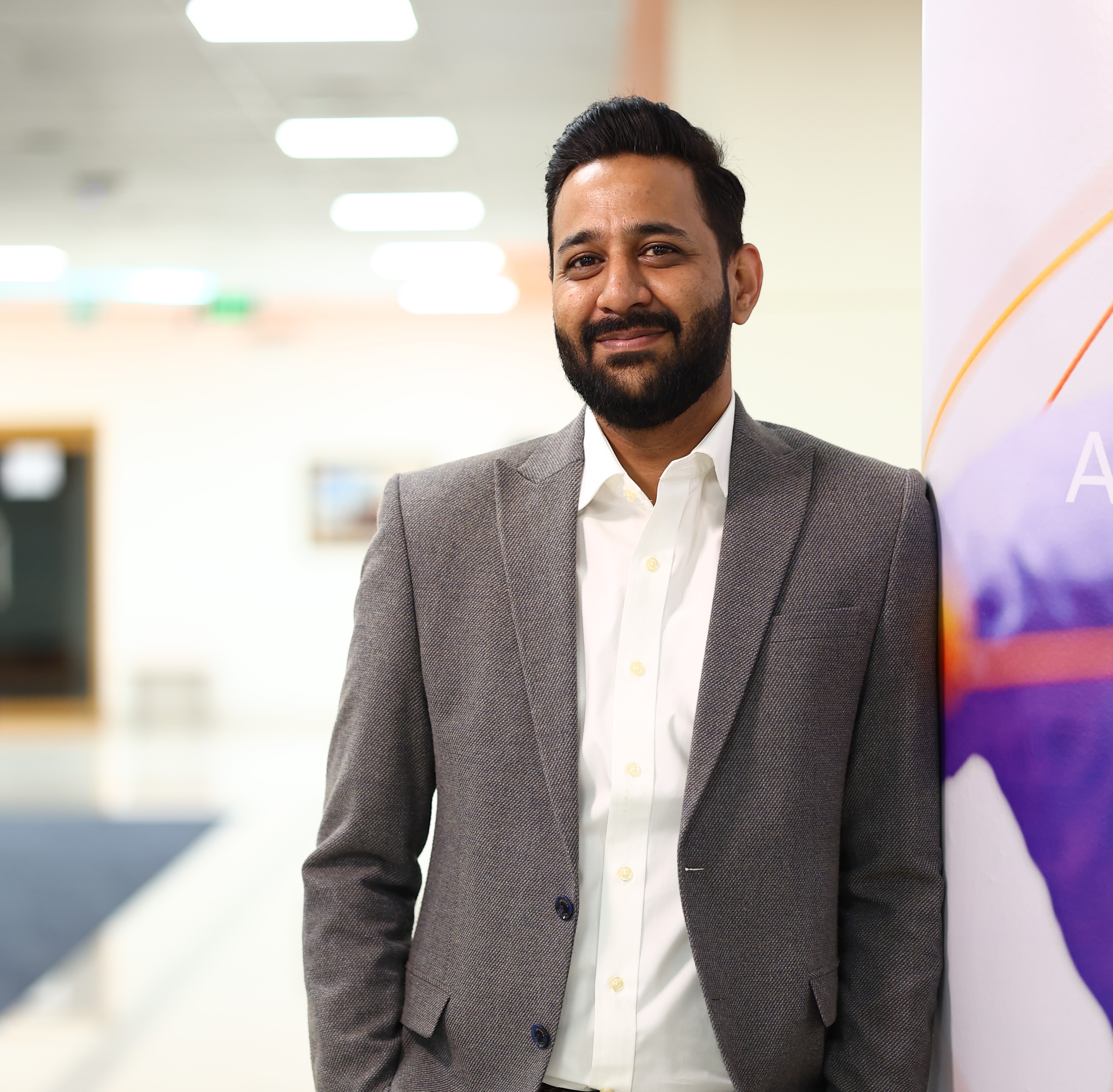 Individual standing and smiling